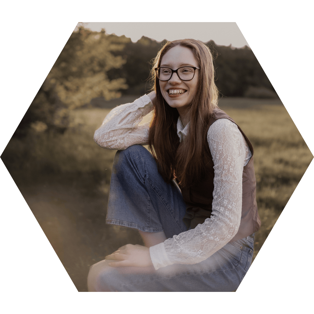 Samantha Liston, inklusive Traurednerin aus NRW, sitzt lachend auf einem Hocker im Abendlicht – ein authentisches Porträt für ihre Website.