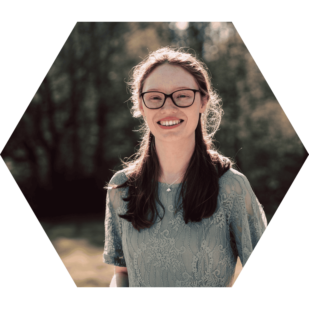 Mantha Liston im Porträt mit Sonnenblumen – Traurednerin für queere, ruhige und sensible Hochzeiten in NRW.