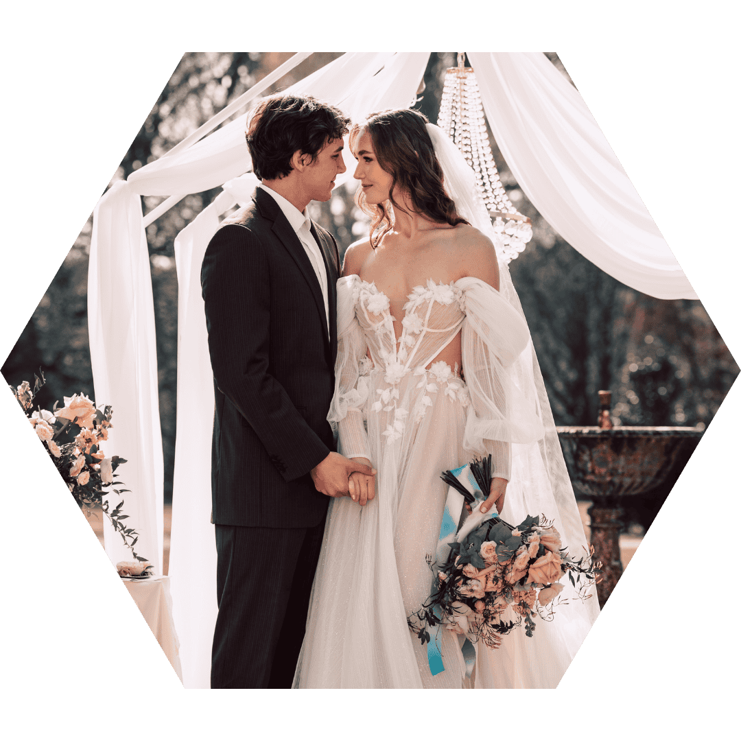 Brautpaar beim intimen Moment – Handkuss vor floraler Kulisse bei einer queeren freien Trauung in NRW.